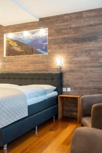 a bedroom with a bed and a wooden wall at Hotel Europe in Davos