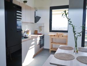 een keuken met een zwarte koelkast en een tafel bij Sunlight Apartment in Skopje