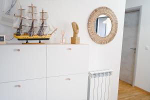 een witte kast met een model van een schip erop bij Sunlight Apartment in Skopje