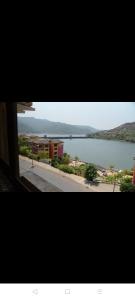 uma vista de uma grande massa de água a partir de uma janela em 2BHK Lake View Apartment em Lavasa