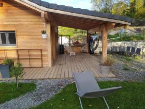 een houten pergola met een stoel in een tuin bij Maisonnette in Talloires