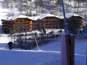 una persona sugli sci di fronte a una baita di tronchi di Appartement de standing au pied des pistes a Morzine