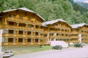 un grande edificio con macchine parcheggiate di fronte di Appartement de standing au pied des pistes a Morzine