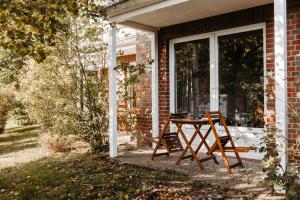 - une table et des chaises sur la terrasse couverte d'une maison dans l'établissement Akzent Hotel Zur Grünen Eiche, à Bispingen