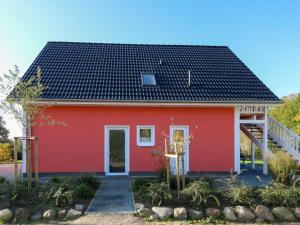 een rood huis met een zwart dak bij Apartment Müritz Ferienpark Röbel-6 by Interhome in Röbel