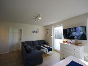 een woonkamer met een bank en een flatscreen-tv bij Apartment Müritz Ferienpark Röbel-6 by Interhome in Röbel