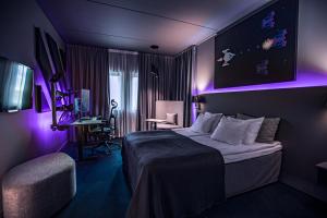 une chambre d'hôtel avec un lit à éclairage violet dans l'établissement Quality Hotel Globe, à Stockholm