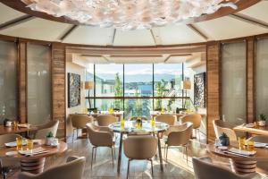 a restaurant with tables and chairs and a large window at Four Seasons Hotel des Bergues Geneva in Geneva