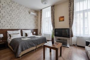 sypialnia z łóżkiem i telewizorem z płaskim ekranem w obiekcie Elit Boutique Rooms- Best Location by BQA w Budapeszcie