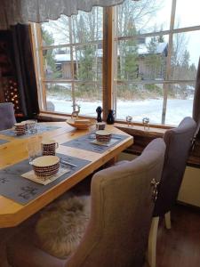 une table à manger avec un chat assis autour de celle-ci dans l'établissement Rukan Kelostar, à Kuusamo