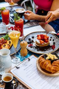 een tafel met borden met eten en drinken bij Aria Hotel Budapest by Library Hotel Collection in Boedapest