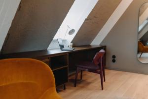 a desk with a laptop and a chair in a attic at Südspeicher in Kappeln