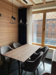 - une salle à manger avec une table et des chaises en bois dans l'établissement Woodside Apartment 431, Kopaonik - One separate bedroom 35m2- FREE Parking & SPA, à Kopaonik