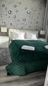 um quarto com uma cama com um edredão verde em Apartament Winnica em Toruń