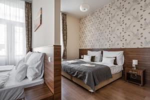 sypialnia z łóżkiem i ścianą z tapetą w kwiaty w obiekcie Elit Boutique Rooms- Best Location by BQA w Budapeszcie