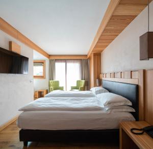 1 dormitorio con 1 cama grande en una habitación en Hotel Larice, en Livigno