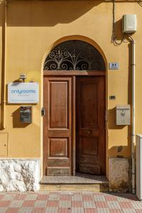 una entrada a un edificio con puerta de madera en Onlyrooms I - Central & Quiet Area, en Cagliari