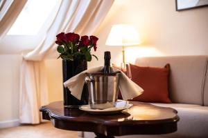 una mesa con una botella de vino y flores. en Altstadthotel Messerschmitt, en Bamberg