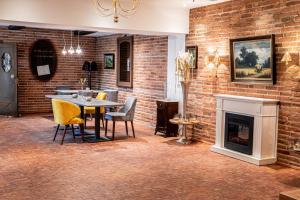 une salle à manger avec un mur en briques, une table et des chaises dans l'établissement Altstadthotel Messerschmitt, à Bamberg