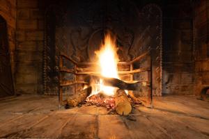 a fireplace with a fire in the middle at Le Relais de la Calèche in Le Beausset