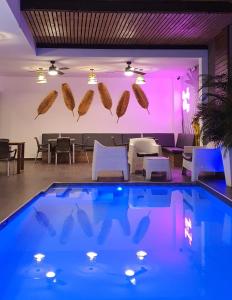 - une piscine avec éclairage violet, tables et chaises dans l'établissement Remfort Hotel, à Santa Ana