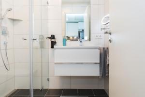 bagno con doccia, lavandino e specchio di SERVENTO Boardinghouse a Erlangen