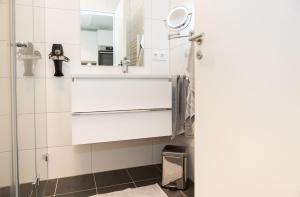 bagno con lavandino e specchio di SERVENTO Boardinghouse a Erlangen