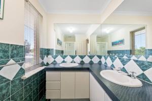 a bathroom with two sinks and a mirror at Light & bright Falcon Bay family holiday escape in Mandurah