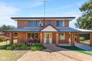 a red brick house with a brick driveway at Light & bright Falcon Bay family holiday escape in Mandurah