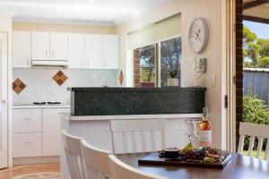 a kitchen with a table with a plate of food on it at Light & bright Falcon Bay family holiday escape in Mandurah