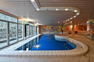 a large swimming pool in a building with a swimming pool at Hotel Akazienhaus in Herzogenaurach