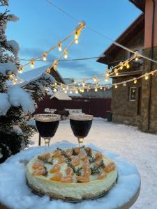 eine Pizza auf dem Tisch mit zwei Gläsern Wein in der Unterkunft Садиба Рокса in Slawske