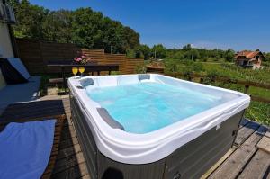 una grande vasca idromassaggio su una terrazza in legno di Holiday Spa House Kostanjevec a Velika Gorica