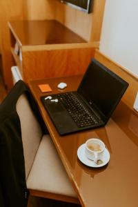 - un ordinateur portable assis sur un bureau avec une tasse de café dans l'établissement Vitoria Praia Hotel, à Vitória