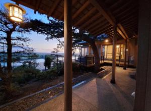 ein Haus mit Blick auf das Meer bei Einbruch der Dunkelheit in der Unterkunft Hitachinaka Villa DAN - ひたちなか 暖 - in Hitachinaka