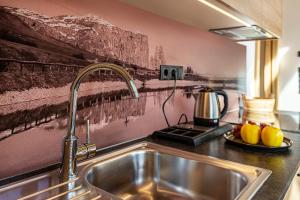 un lavandino in cucina con una foto sul muro di Zu Grof Morgenrot a Castelrotto