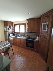 a kitchen with wooden cabinets and a stove top oven at Chalet en el Pirineo de Aragón in Neril