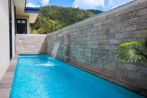 una piscina con cascata in un muro di mattoni di 180 Degrees a Cannonvale