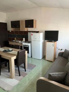 ein Wohnzimmer mit einem Sofa und einer Küche in der Unterkunft Apartments Vila Brzi & Beka in Šabac