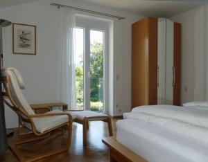 - une chambre avec deux lits, une chaise et une fenêtre dans l'établissement Kaufhold Ferienwohnung, à Immenstadt