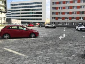 un coche rojo está estacionado en un estacionamiento en 111Apartments, en Košice