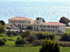 une grande maison blanche en face de l'océan dans l'établissement Finiki Plaza, à Methoni