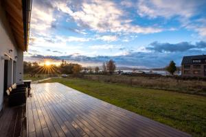 een houten terras met uitzicht op een veld bij Vila Jestřábí s výhledem na Lipno, klidná lokalita in Černá v Pošumaví