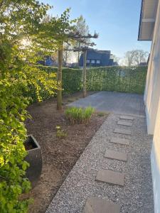 un jardín con una pasarela junto a un edificio en Schöne Ferienwohnung im Ergeschoss mit Terrasse, en Ahaus