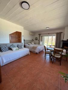 een slaapkamer met 2 bedden en een tafel en stoelen bij El Diablo Chic Colonial in Punta Del Diablo