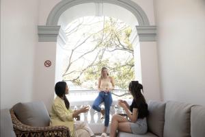 een groep van drie vrouwen die in een woonkamer wijn drinken bij The Pacific House in Sydney