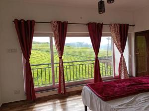 een slaapkamer met een groot raam met uitzicht bij Tea Estate view stay in Ooty