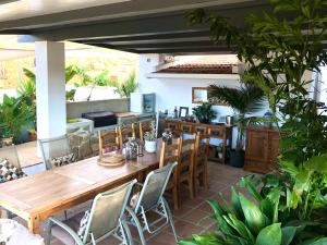 een patio met een houten tafel en stoelen bij Finca Las Campanas II in Villanueva de la Concepción