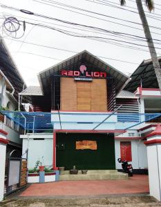 un edificio con sopra un segno rosso di leone di RED LION a Varkala