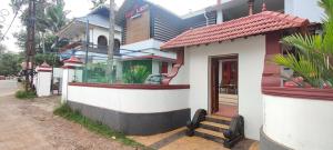 una piccola casa con una finestra su una strada di RED LION a Varkala